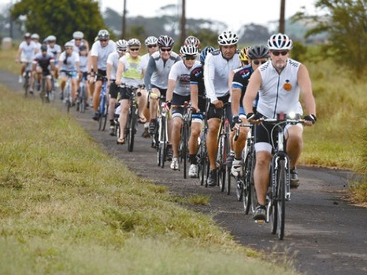 a group of people riding on the back of a bicycle